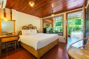 a bedroom with a bed and a mirror and a desk at Mango Village in Phú Quốc +144 photos