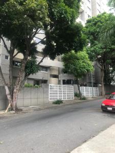 a red car parked in front of a building at DORADO Top Spot en el Rosal Agua Fibra y Seguridad 24 horas in Caracas