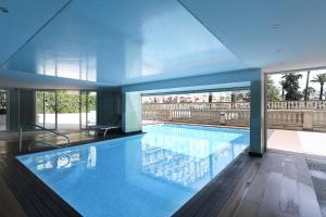 a large swimming pool in a building at Victoria Sole & Mare with Sea View Terrace - Happy Rentals in Menton