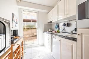 a kitchen with white cabinets and a window at Victoria Sole & Mare with Sea View Terrace - Happy Rentals in Menton
