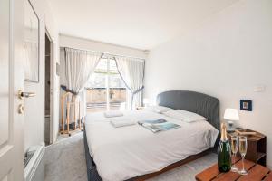 a bedroom with a large white bed with a window at Victoria Sole & Mare with Sea View Terrace - Happy Rentals in Menton