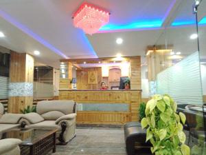 a living room with couches and chairs and a table at Marina Group of hotel Naddi mountain view -cricket stadium 9 km-Mcleodganj 2 km- Bhagsunag 4 in Dharamshala