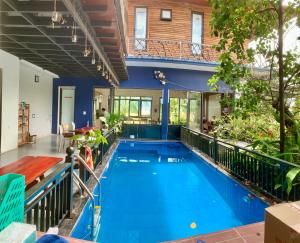 an indoor swimming pool with blue water in a house at A Thía homestay in Diện Biên Phủ