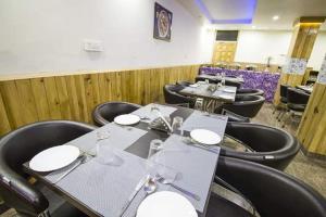 a dining room with tables and black chairs at Mountain Mount view # triund track 2 km#Free Parking-cricket stadium 8 km-Mcleodganj 2 km in Dharamshala +4 photos