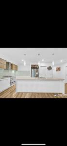a kitchen with white cabinets and a white counter top at Lavish private room1 in Truganina