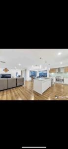 a large living room with white furniture and wooden floors at Lavish private room1 in Truganina +1 photo