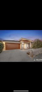 a large house with a wooden garage door at Lavish private room1 in Truganina