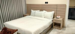 a bedroom with a white bed with a wooden headboard at قمة قباءللشقق المفروشه1 in Medina