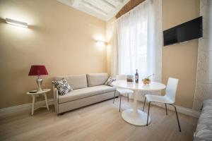 un soggiorno con divano e tavolo di Apartments Lorenzo&Lorenzo a Firenze