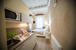 a kitchen with a sink and a bed in a room at Apartments Lorenzo&Lorenzo in Florence +48 photos