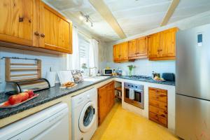 a kitchen with wooden cabinets and a stainless steel refrigerator at Il-Mohba Holiday Home in Munxar