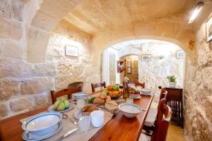 a dining room with a table with fruit on it at Il-Mohba Holiday Home in Munxar