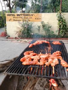 a bunch of meat cooking on a grill at Hotel Butterfly - Peaceful Garden for Nature Lovers in Sauraha