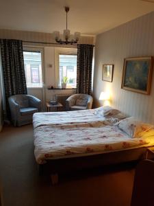 a bedroom with a large bed and two chairs at Hotell Bode in Karlshamn