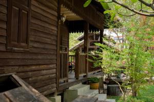 a wooden house with stairs leading to the porch at Baan Phraya Suren บ้านพระยาสุเรนทร์ in Ban Thab Mak