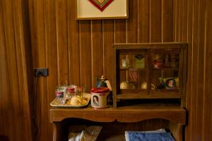 a wooden wall with a shelf with food on it at Baan Phraya Suren บ้านพระยาสุเรนทร์ in Ban Thab Mak