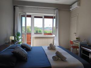 a bedroom with a blue bed with a large window at Appartamento Turistico Monterotondo in Monterotondo