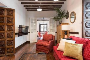a living room with a red couch and a chair at Casa Espiritu Santo in Las Palmas de Gran Canaria