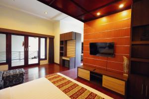 a large living room with a tv on a wall at The Nakula Villas in Legian