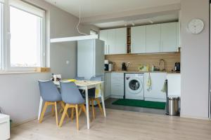 a kitchen with white cabinets and a table and chairs at Desitas home in Plovdiv