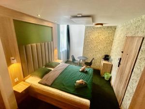 a bedroom with a green bed with a person laying on it at Stacja Jeżyce Pokój #B in Poznań