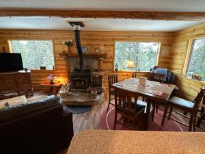 a living room with a table and a fireplace at Beautiful Sierra Mountain Cabin in Springville