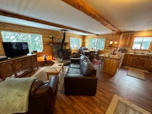 a living room with a couch and a kitchen at Beautiful Sierra Mountain Cabin in Springville