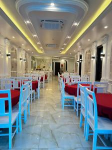 a restaurant with red and blue tables and chairs at Paloma Hotel Quan Lan in Quan Lạn +10 photos