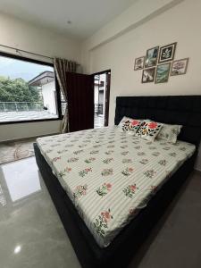 a bedroom with a bed with a comforter on it at Cloud & Calm Homestay in Dharmsāla