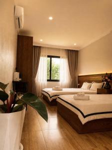 a hotel room with two beds and a window at SaPa PAPA - Architect's Hidden Sanctuary - Only 4 rooms hidden in a secret botanical garden - 3 minutes from Sapa Station - Privacy & Privilege for stylish insiders in Sapa