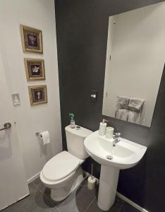 a bathroom with a white toilet and a sink at Art Deco Chic on Queen in Auckland