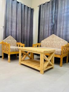 two chairs and a table and a table and benches at SINDOM APARTMENTS Dodoma in Dodoma