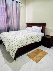 a bedroom with a bed with a wooden headboard at SINDOM APARTMENTS Dodoma in Dodoma