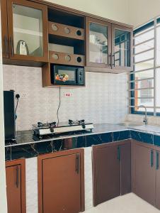a kitchen with brown cabinets and a counter top at SINDOM APARTMENTS Dodoma in Dodoma