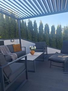 a patio with two couches and a table and chairs at Villa med pool in Bara +31 photos