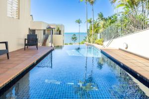 a swimming pool in front of a house at Eight, Villa Mar Colina in Yeppoon