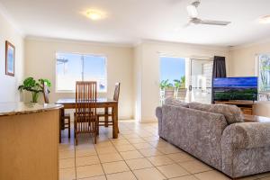 a living room with a couch and a table at Eight, Villa Mar Colina in Yeppoon