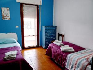 a bedroom with two beds and a dresser in it at Soverato Appartamento Trilocale Ippocampo - Accogliente, Moderno e a pochi passi dal mare in Soverato Marina