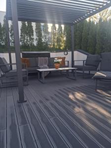 a patio with couches and a table on a deck at Villa med pool in Bara