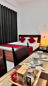 a hotel room with two beds and a table with plates of food at Air Route Transit in Seeduwa