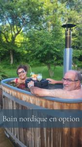 a man and a woman in a hot tub at Ô Pays Des Bois - Bulles et logements insolites en pleine nature - Adults Only in Parmilieu