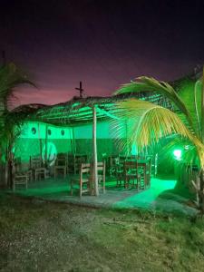 a church with a green lighting in front of a building at POSADA VSTIKIBAR & RESTAURANt in Rincón del Pirata