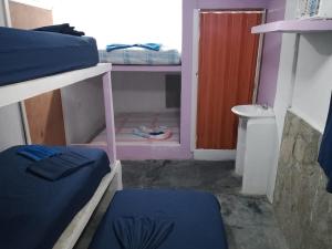 a small room with two bunk beds and a door at POSADA VSTIKIBAR & RESTAURANt in Rincón del Pirata