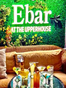 a glass table with drinks on a couch with a sign that reads alert at at The Upperhouse Hotel Boutique Stay with City & River Views in Cagayan de Oro +24 photos