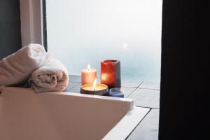 a box with two candles and towels on a tile floor at The Upperhouse Hotel Boutique Stay with City & River Views in Cagayan de Oro
