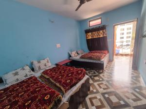 ein Zimmer mit zwei Betten und einer Couch in der Unterkunft Devom Guest House in Phata