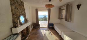 a living room with a stone fireplace and a window at Belvedere de Canaloro in Sari Solenzara