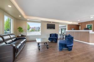 a living room with a leather couch and blue chairs at Econo Lodge Inn & Suites in Kelowna