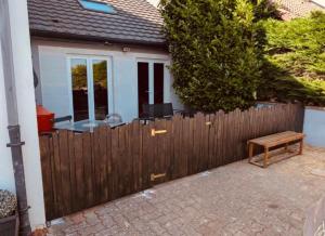 a wooden fence in front of a house at La Mariefacture - Comme au Garage in Laning