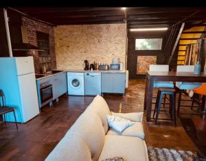 a living room with a couch and a kitchen at La Mariefacture - Comme au Garage in Laning